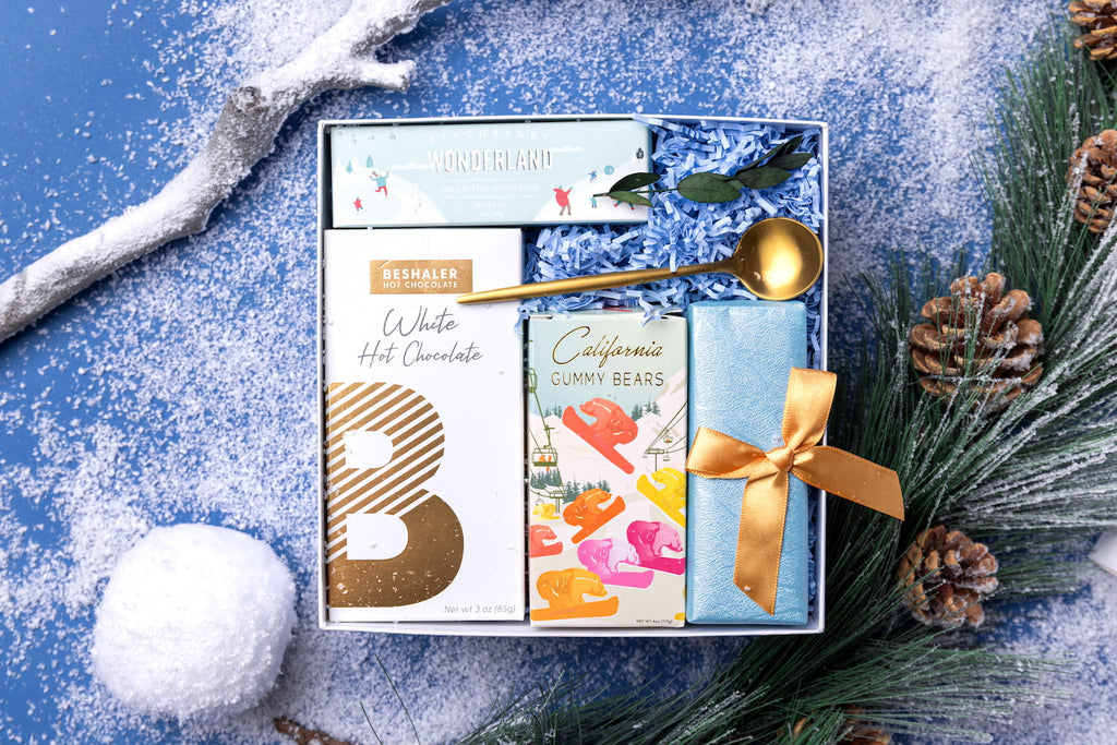 Winter wonderland holiday gift box with artisanal treats and hand cream.